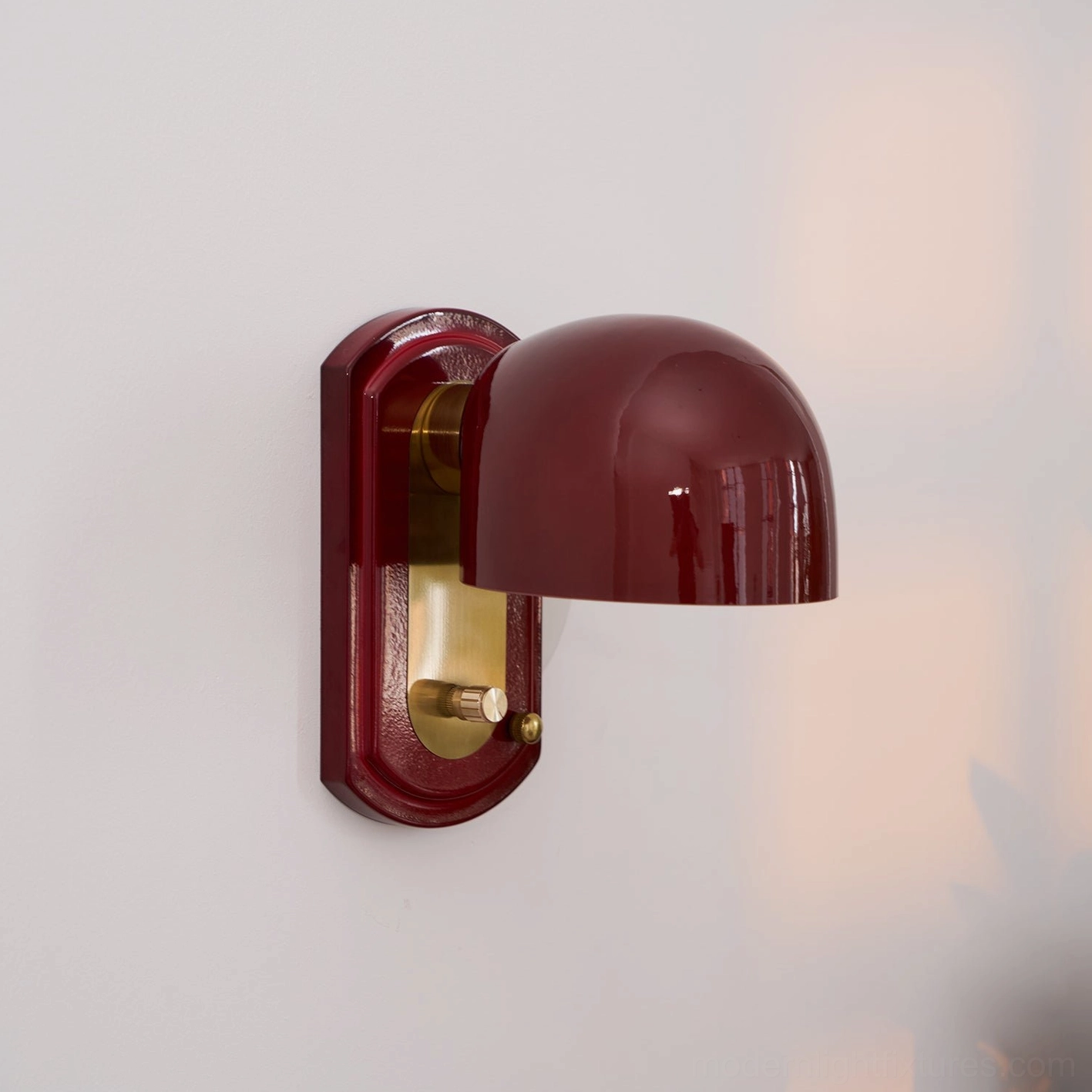Lolita wall sconce paired above decorative mirror creating symmetrical balanced wall composition for foyer