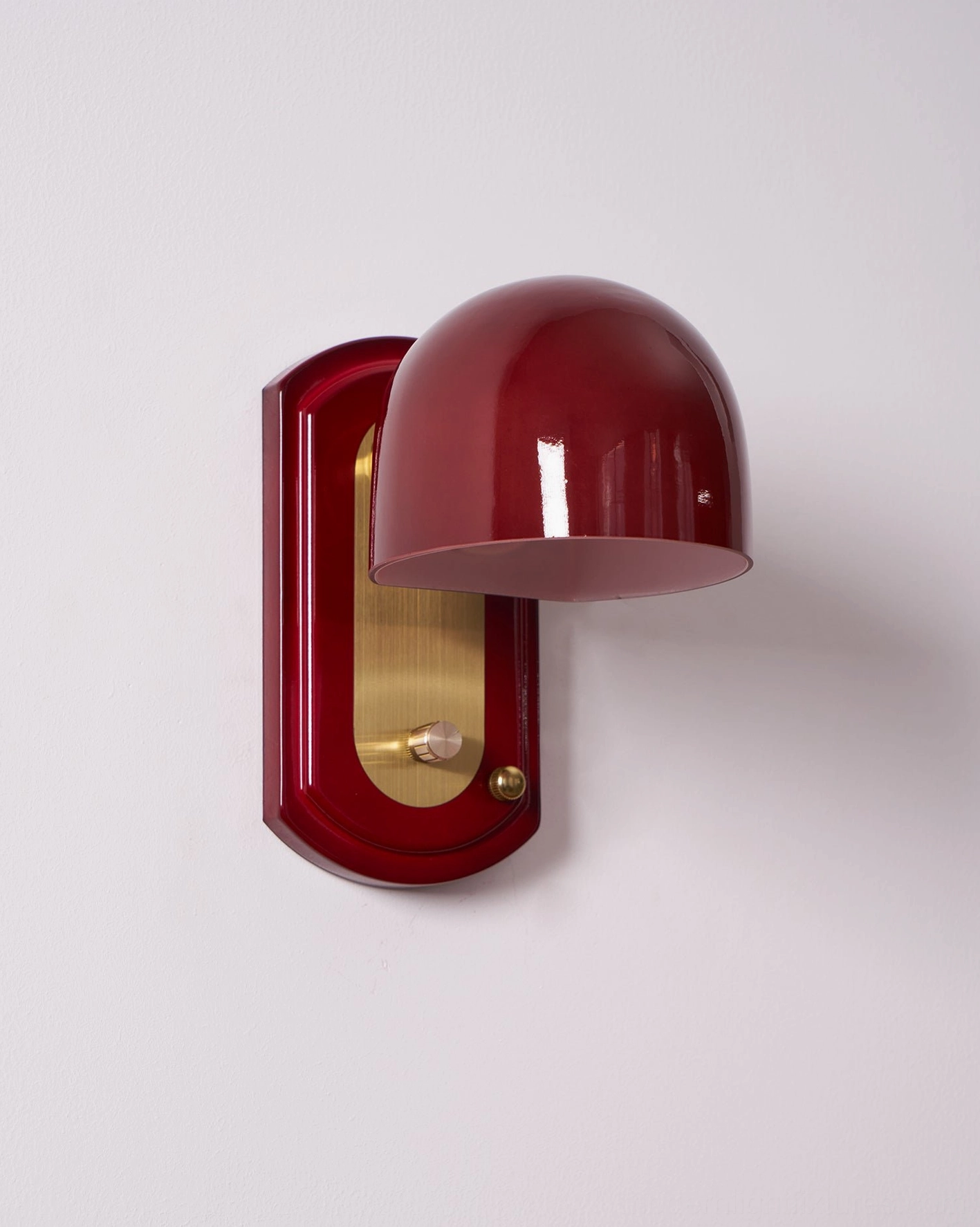 Lolita wall sconce mounted beside decorative wall panels creating layered lighting and visual interest focal point