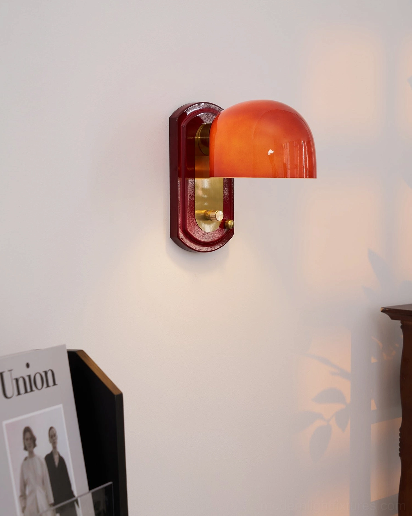 Lolita dome sconce mounted on gallery wall arrangement as sculptural design element among artwork and mirrors