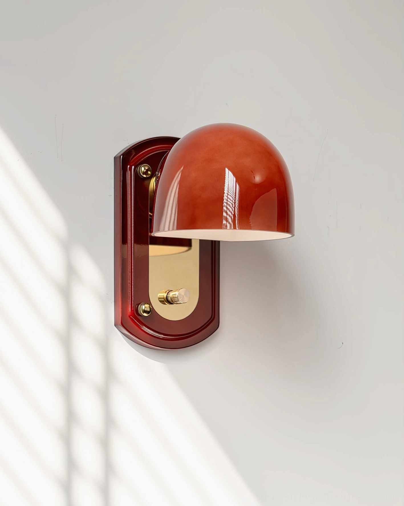 Lolita dome sconce mounted on white wall with warm glowing light effect, three-quarter view with light shadows