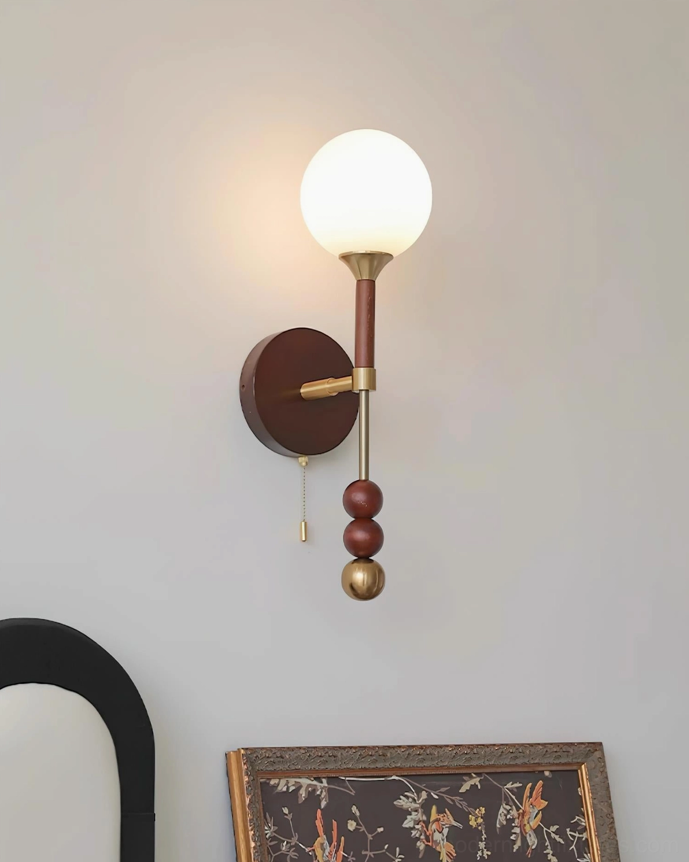 Lolli sculptural wall lamp showing spherical glass shade and decorative metal elements