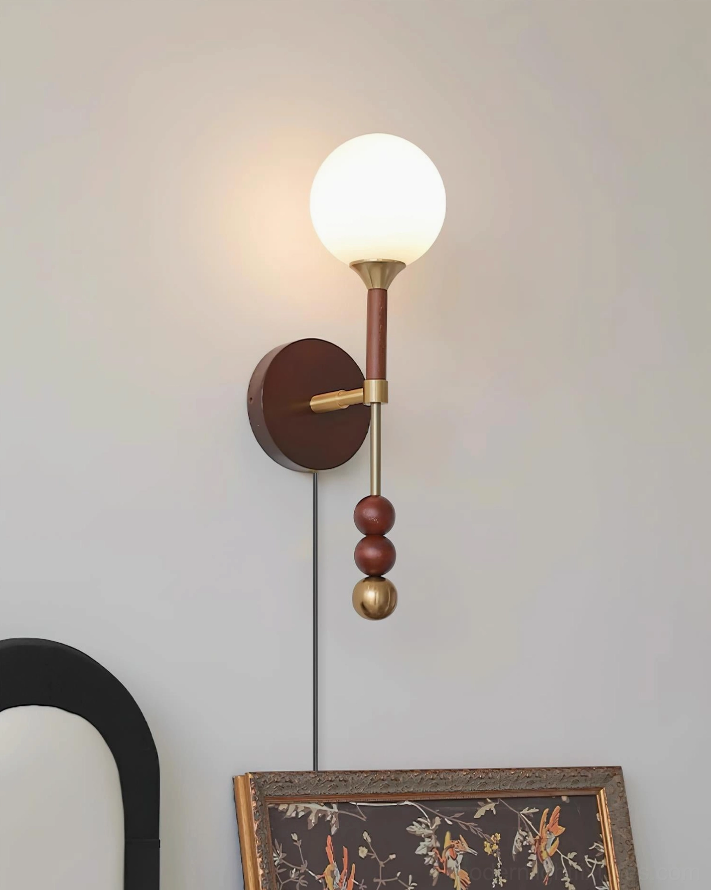 Lolli modern wall sconce with brass metal accents and wood body mounted in bedroom beside framed artwork