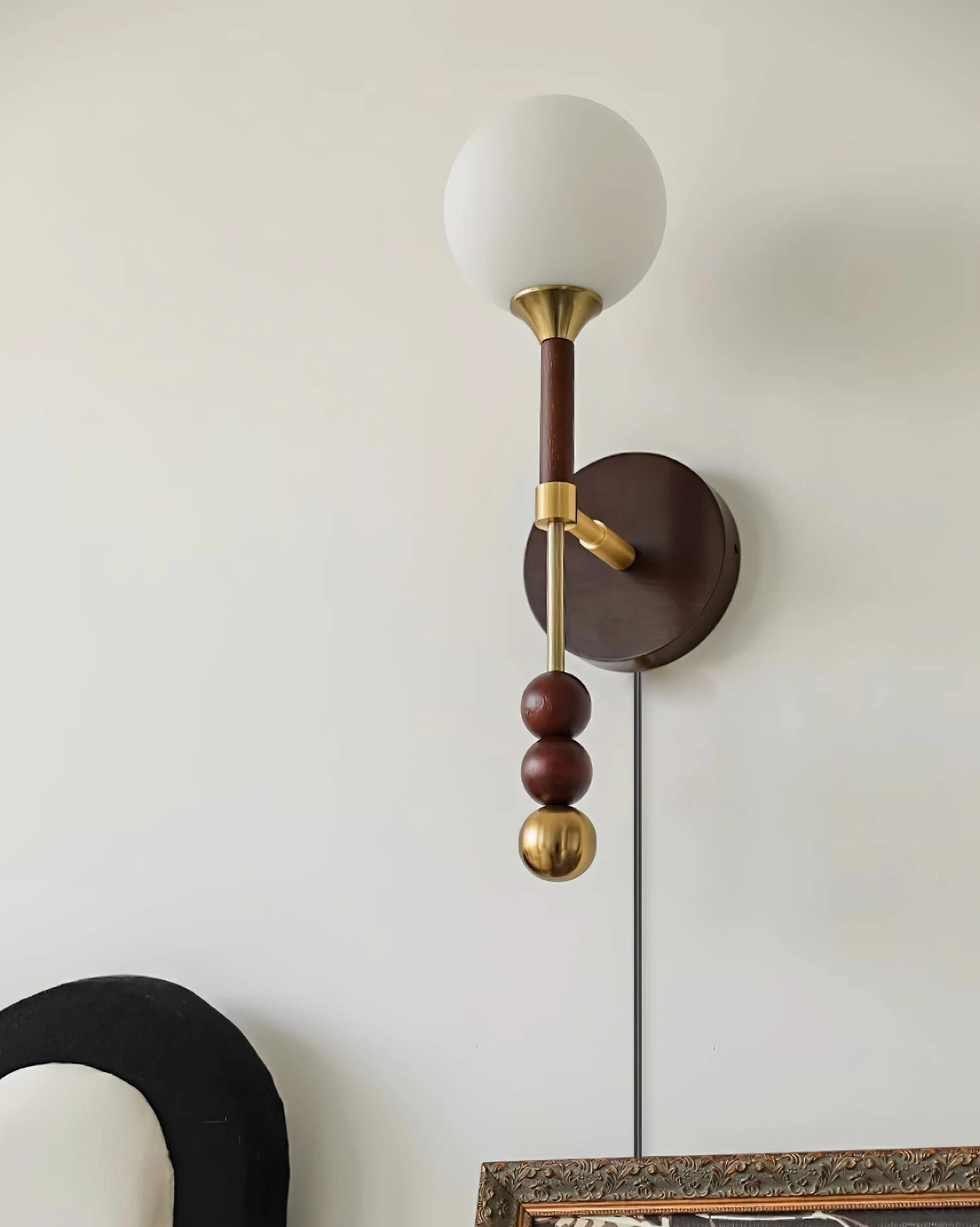 Lolli plug-in wall sconce detail view showing frosted glass orb and geometric sphere construction