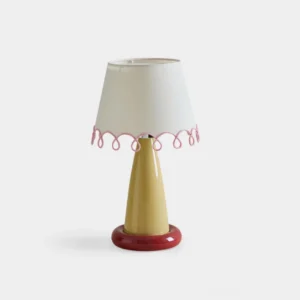 Lollio ceramic table lamp with yellow stem and red base, front low-angle view showcasing white fabric shade with pink scalloped trim details