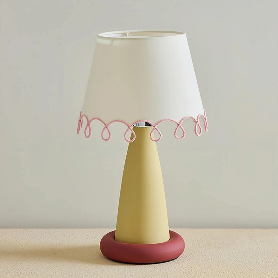 Lollio modern ceramic table lamp with yellow stem and red base, unlit shade on neutral gray studio backdrop