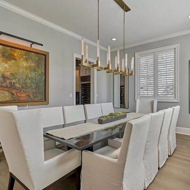 Long linear chandelier 55 inches brass frame with frosted ribbed glass shades in formal dining space