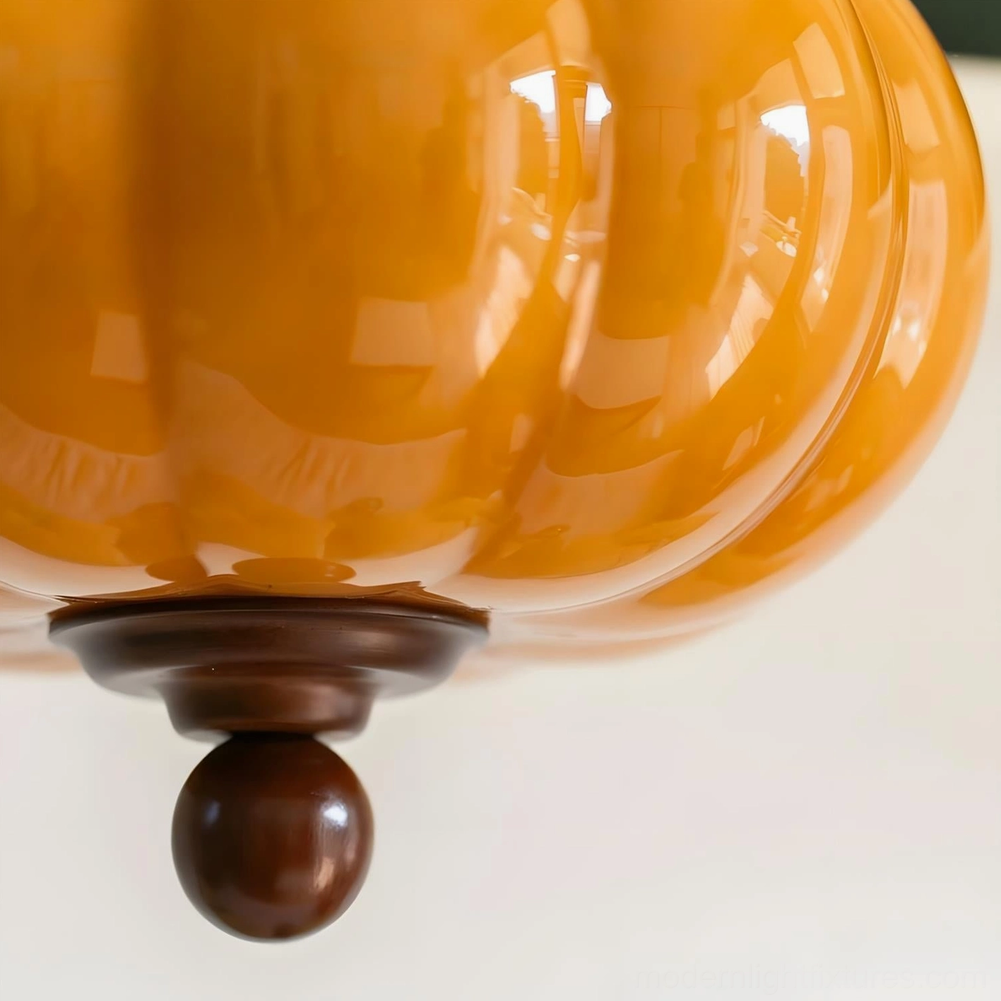 Detailed view of Lucerna amber glass globe with turned walnut finial and wood components