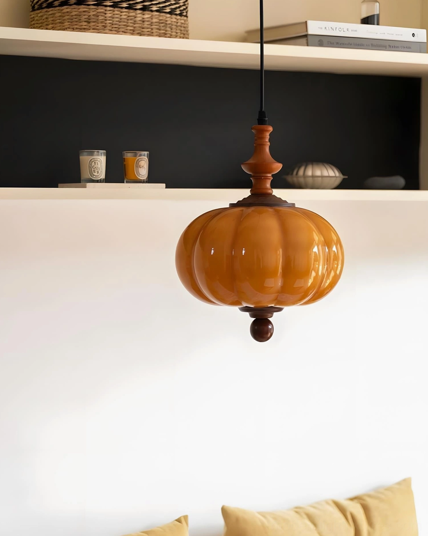 Amber ribbed glass pendant fixture with turned walnut wood accents on floating shelf