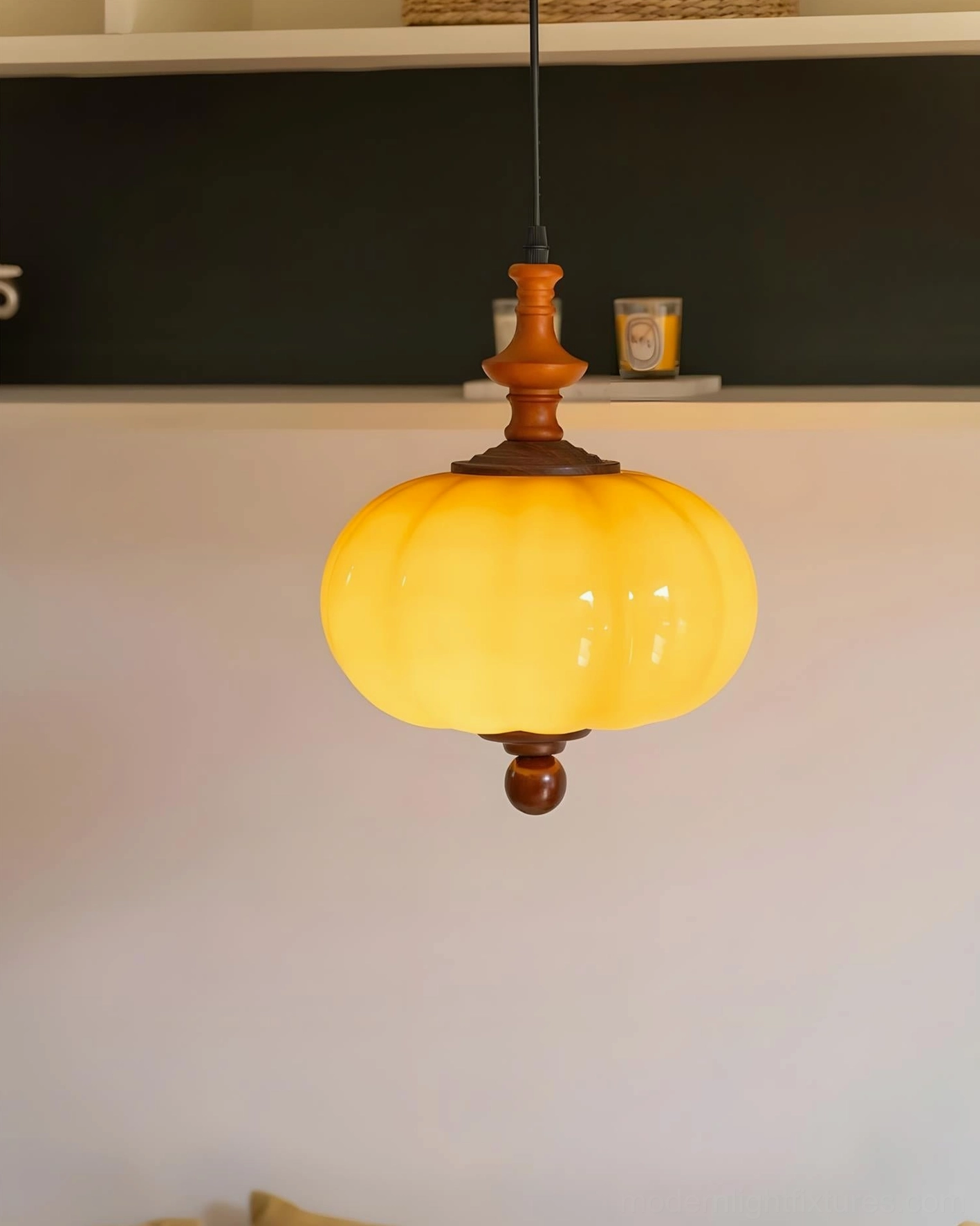 Warm cream and amber pumpkin-shaped pendant light mounted on interior wall