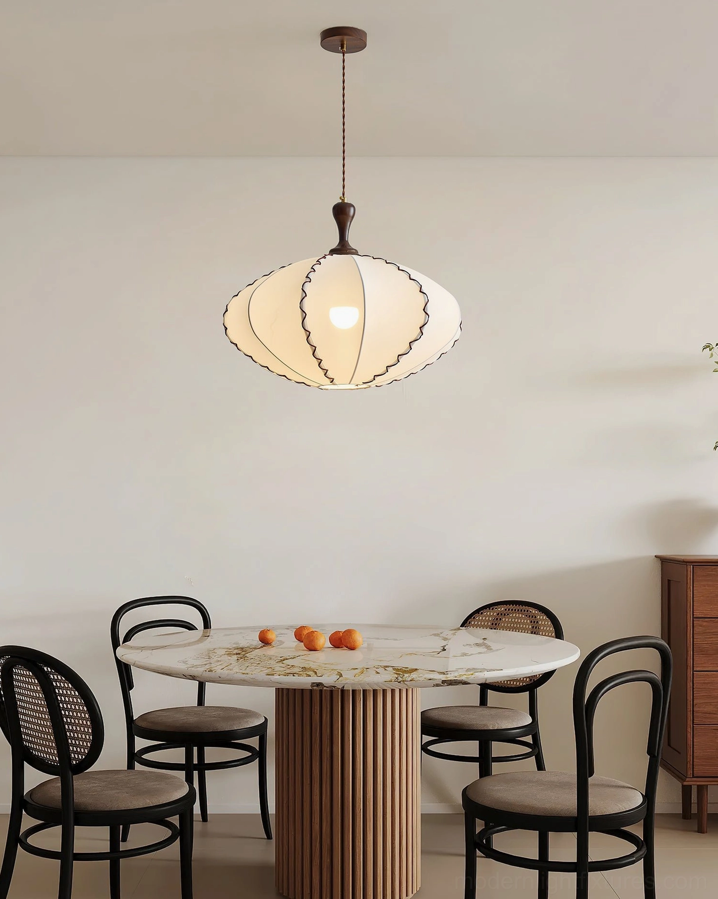 Lucian scalloped pendant light providing ambient illumination above round marble-top dining table in residential interior
