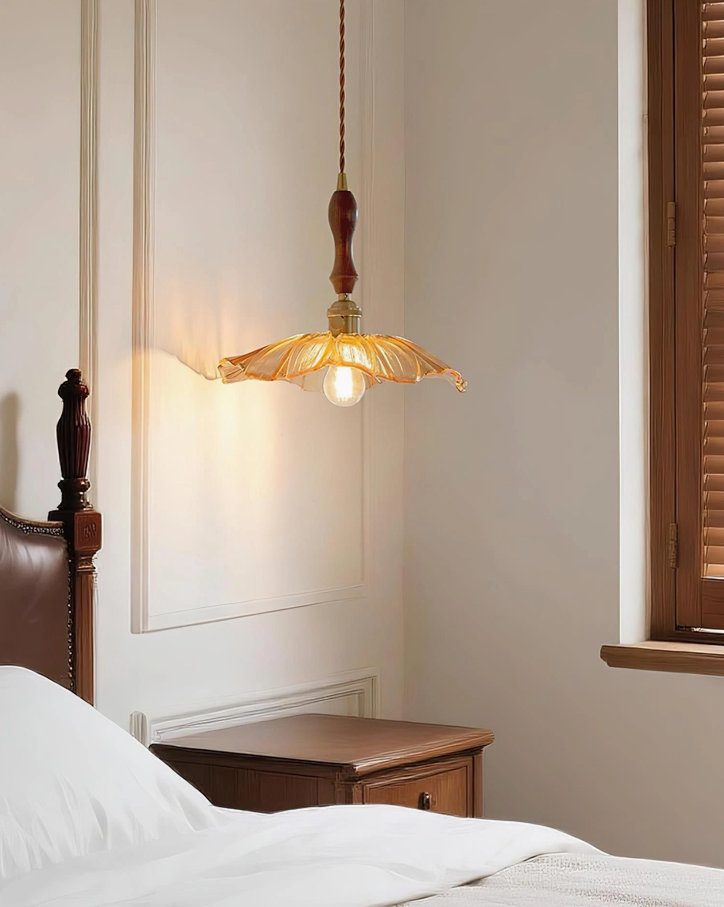 Amber glass pendant light in vintage bedroom interior, warm diffused glow, lotus-shaped fluted lampshade