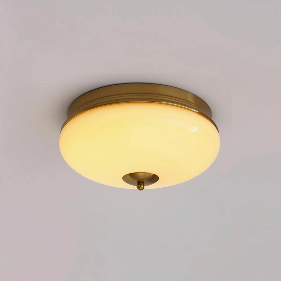 Vintage-inspired Ludo brass ceiling light with warm yellow glow and amber-tinted frosted glass