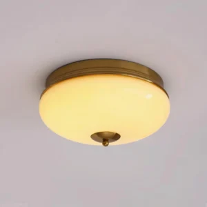 Modern Ludo brass ceiling fixture with illuminated frosted glass dome and matte brass metal trim