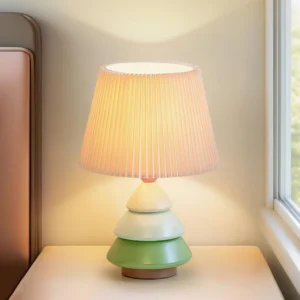 Luma Globe table lamp three-quarter view in blue and pink color variant with warm light glow in bedroom bedside setting