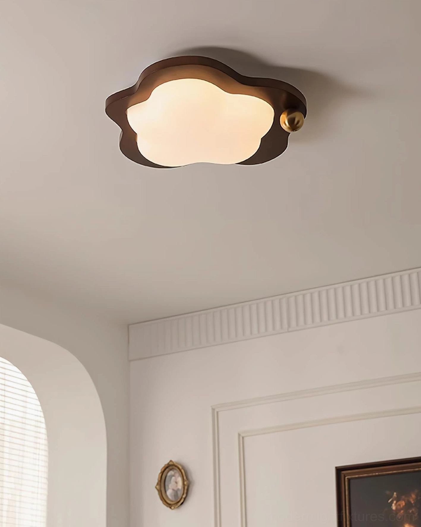 Close-up overhead view of walnut cloud ceiling light fixture with brass detail on crown molding