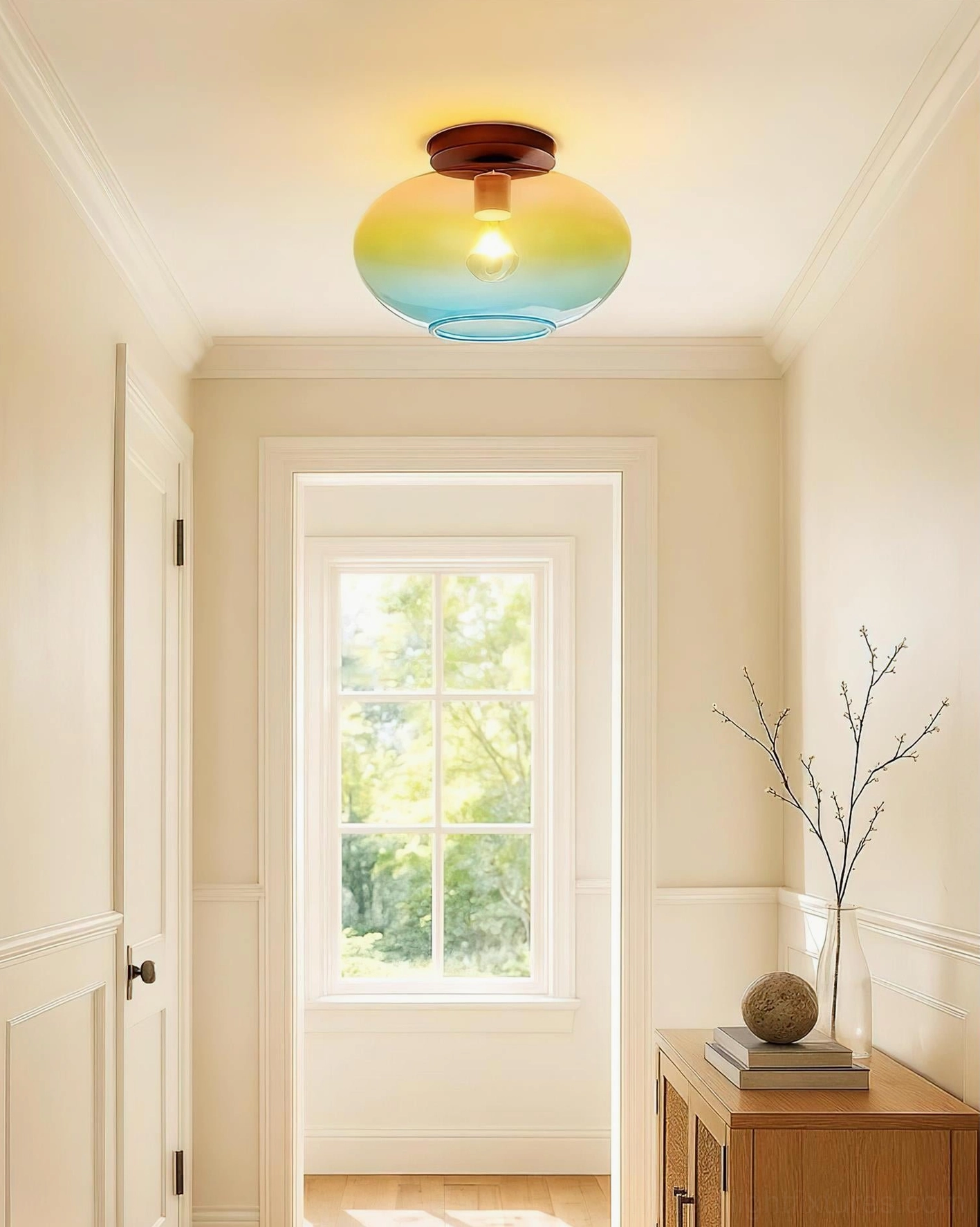 Lumia ombré ceiling fixture installed in residential hallway entryway with warm neutral decor and decorative branch accent