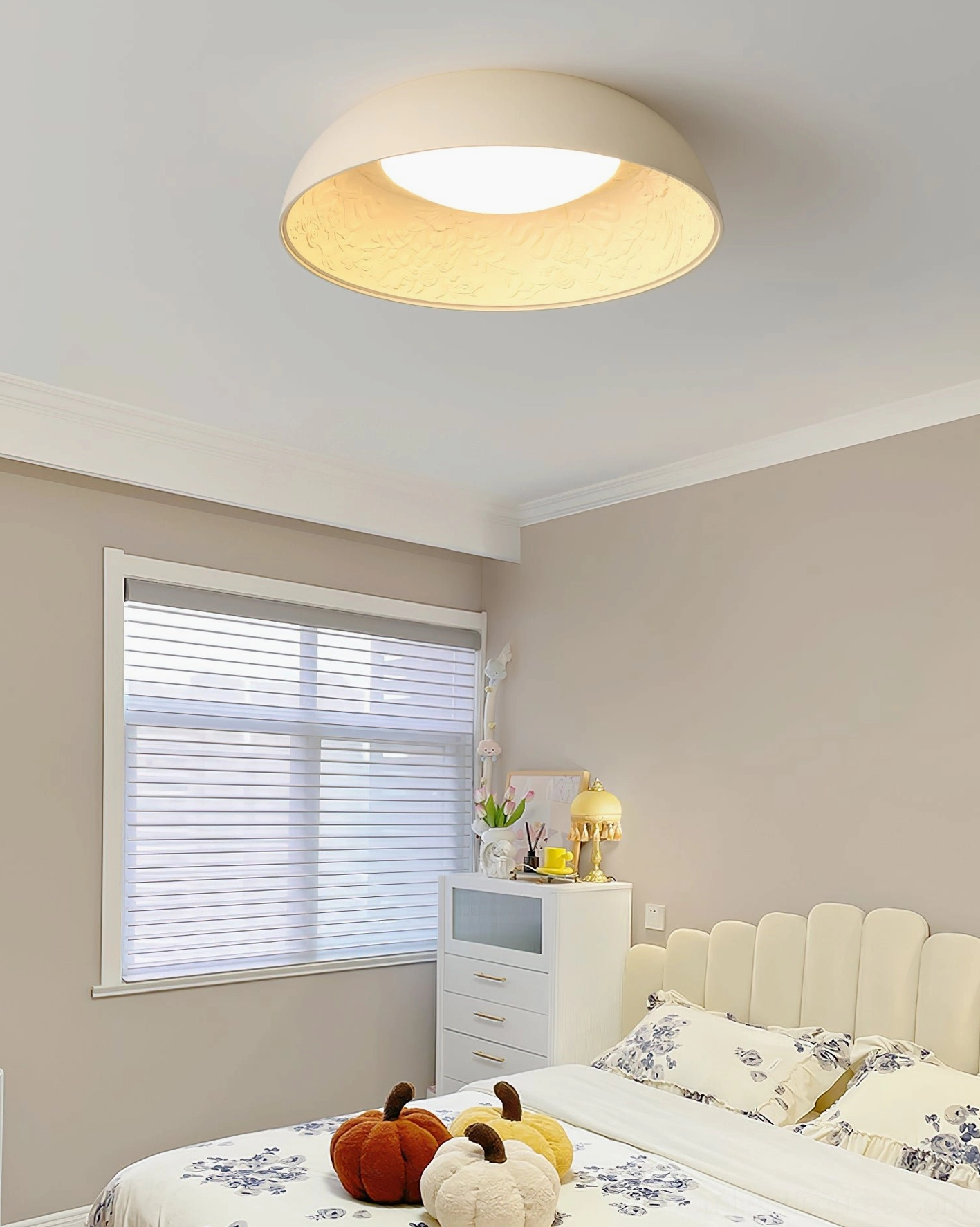 Lumina flush mount light in residential bedroom with window blinds and tufted headboard