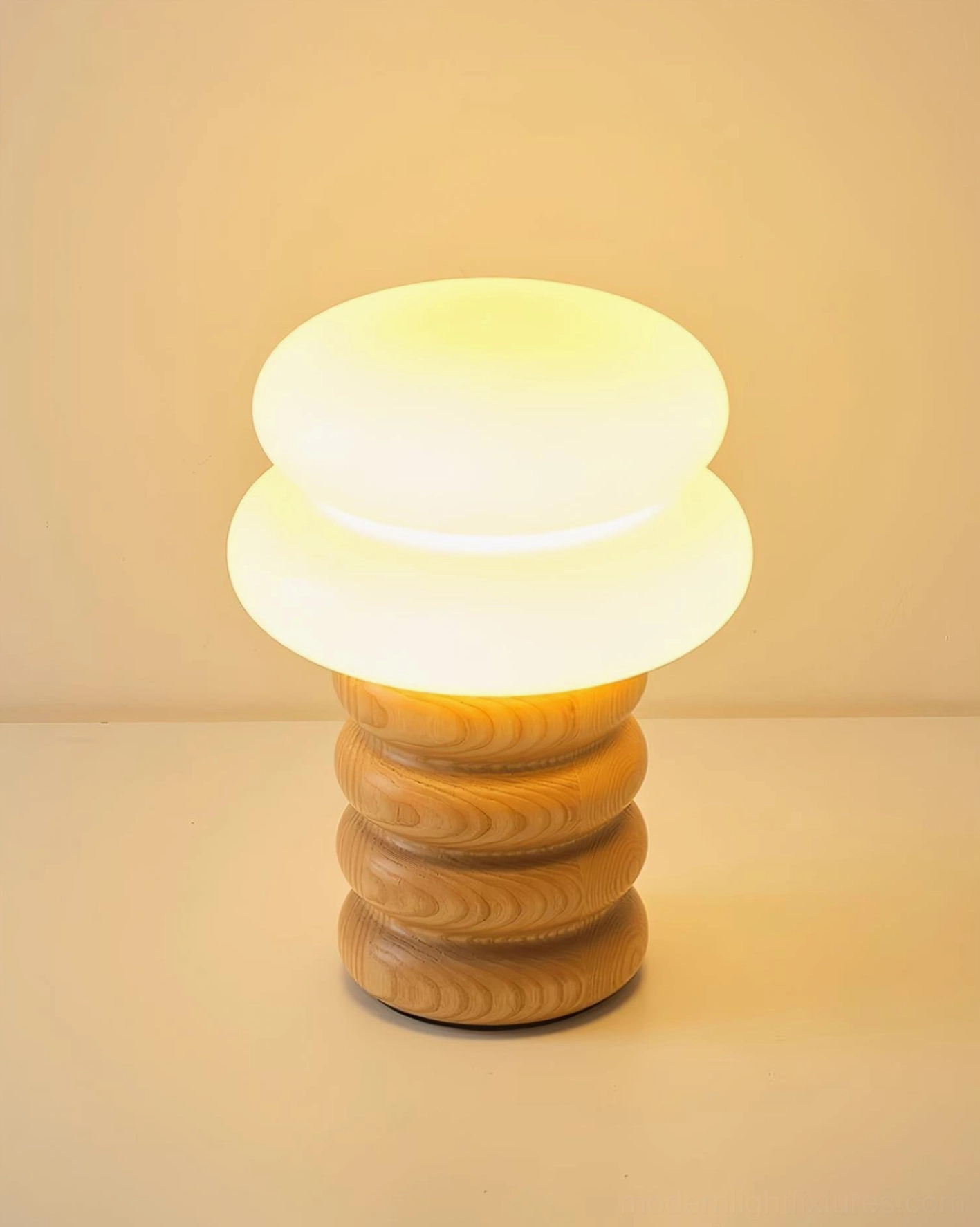 Lumina table lamp illuminated close-up showing warm light through milky glass shade