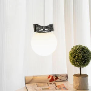 Luna pendant lamp displayed above side table with sheer curtains and topiary decor, indoor lighting