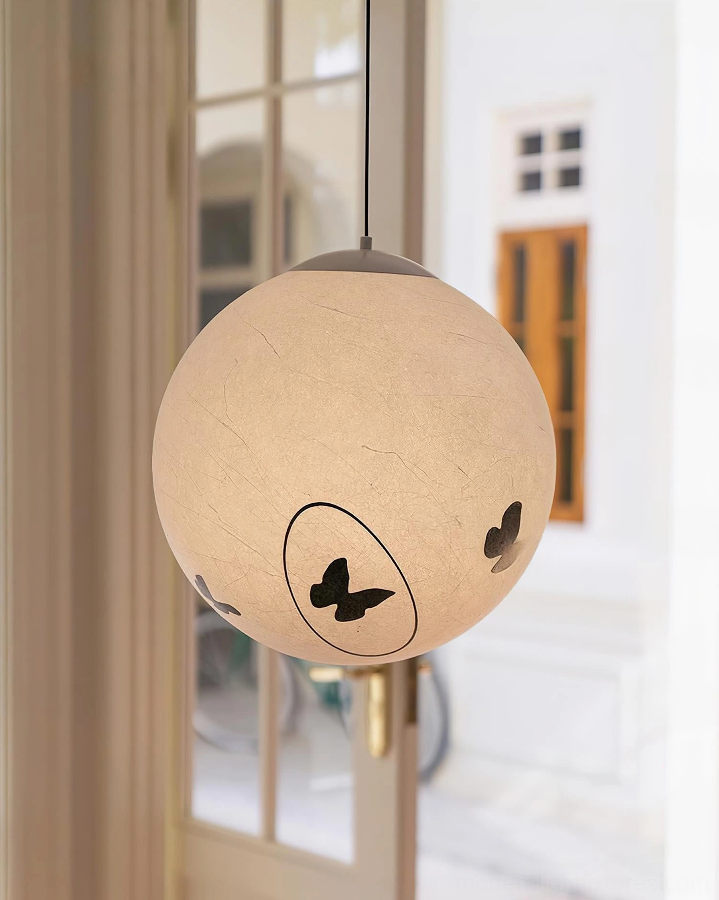 Luna Flutter butterfly pendant lamp installed in minimalist hallway with cream wall panels, contemporary interior design