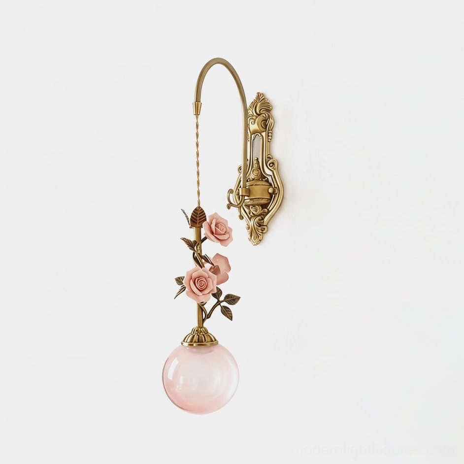 Lunafleur brass wall sconce with porcelain rose details and pink frosted glass globe front view studio shot