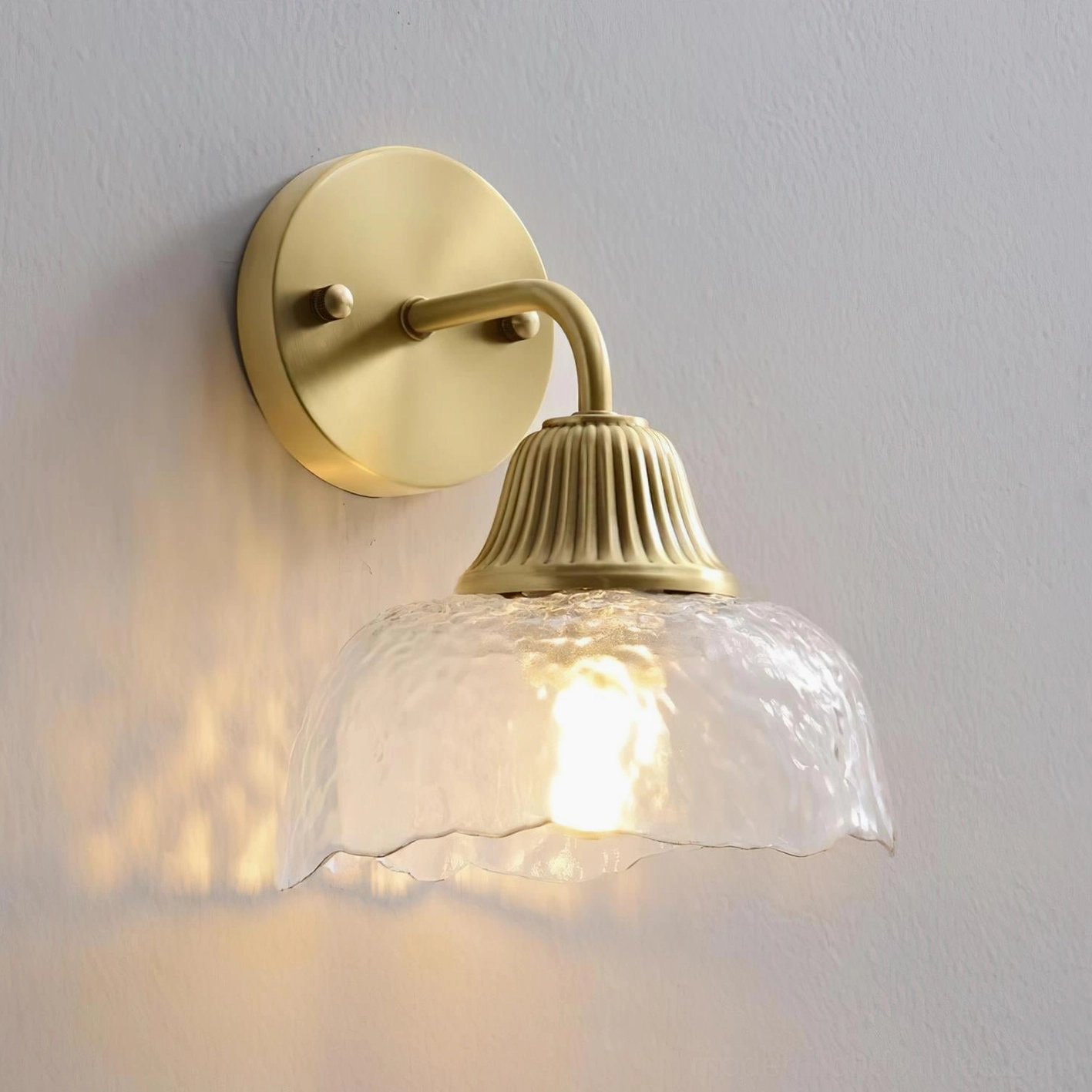 Lunara hand-hammered glass wall sconce light diffusion artisanal craftsmanship detail close-up