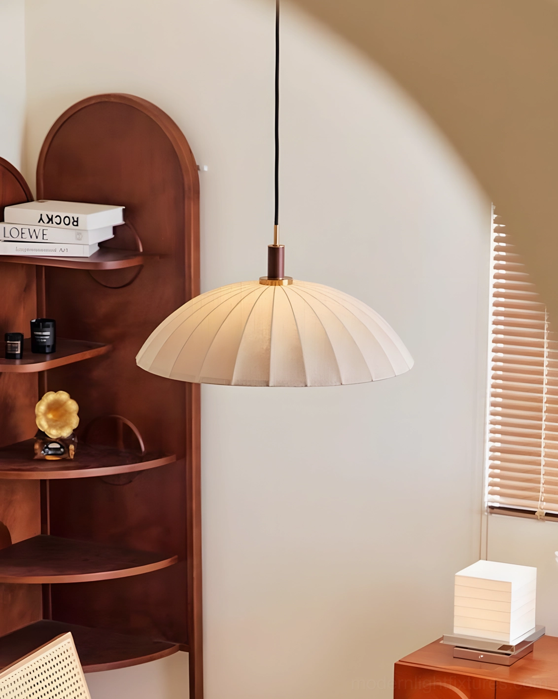 Lunaro pleated dome pendant side three-quarter view in cozy minimalist home interior with arched shelf
