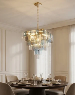 Lunebelle chandelier suspended over formal dining table in residential dining room, overhead view showing tri-tone cast glass blocks and prismatic light effect