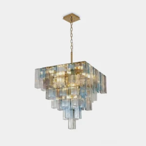 Lunebelle four-tier square glass chandelier with clear, ice-blue and smoky-tan cast glass blocks on brass frame and chain, front studio view isolated on white background