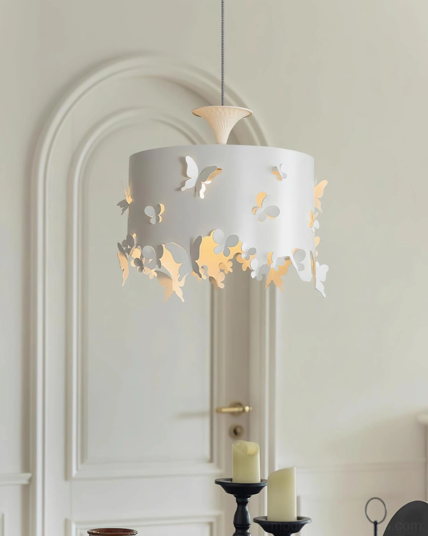Butterfly pendant light suspended in modern entryway with arched white door, warm ambient lighting creating romantic shadows
