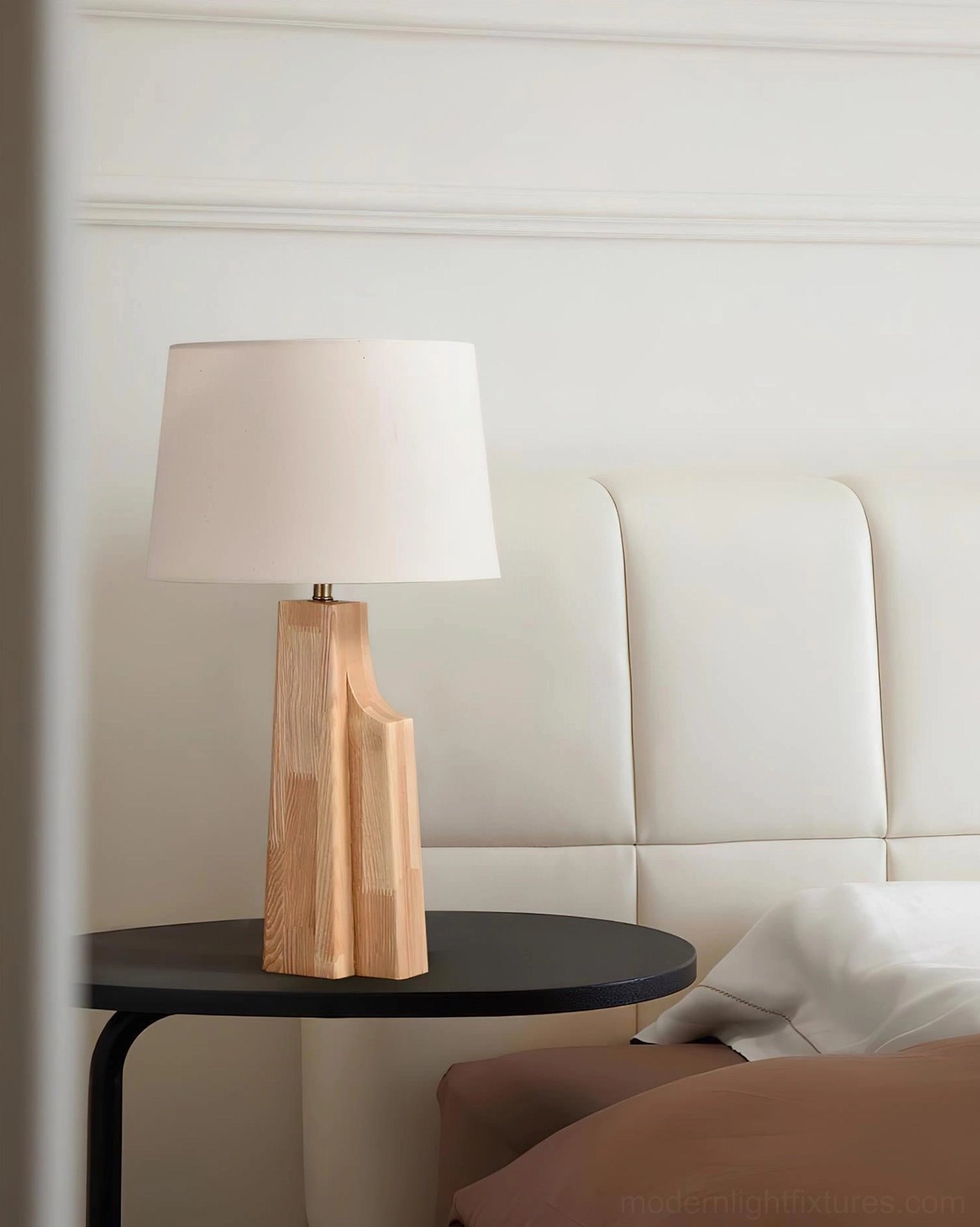 Lunet table lamp bedside placement on black side table with warm ambient lighting in modern bedroom