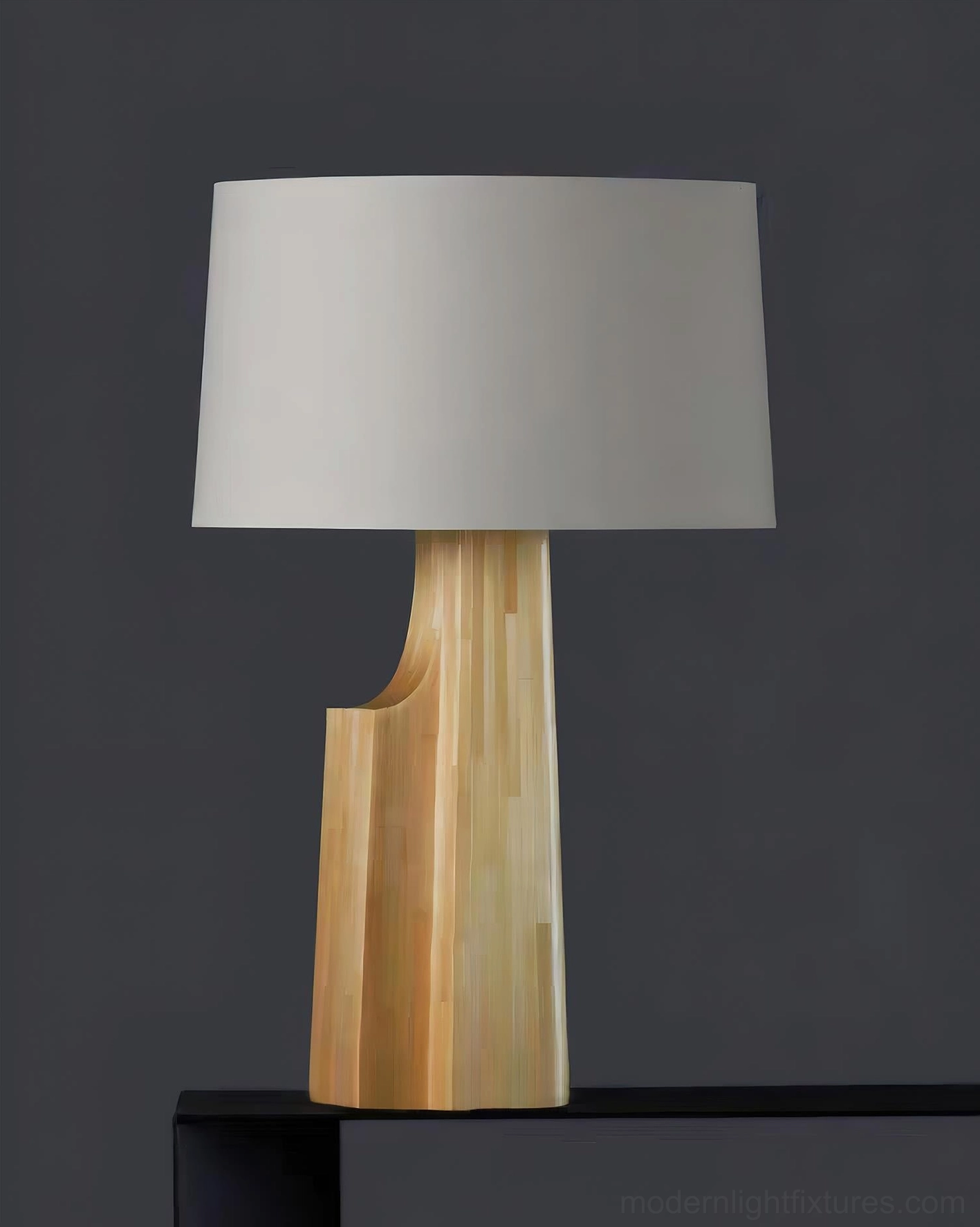 Lunet minimalist table lamp front view on black shelf with curved wooden base and cream shade