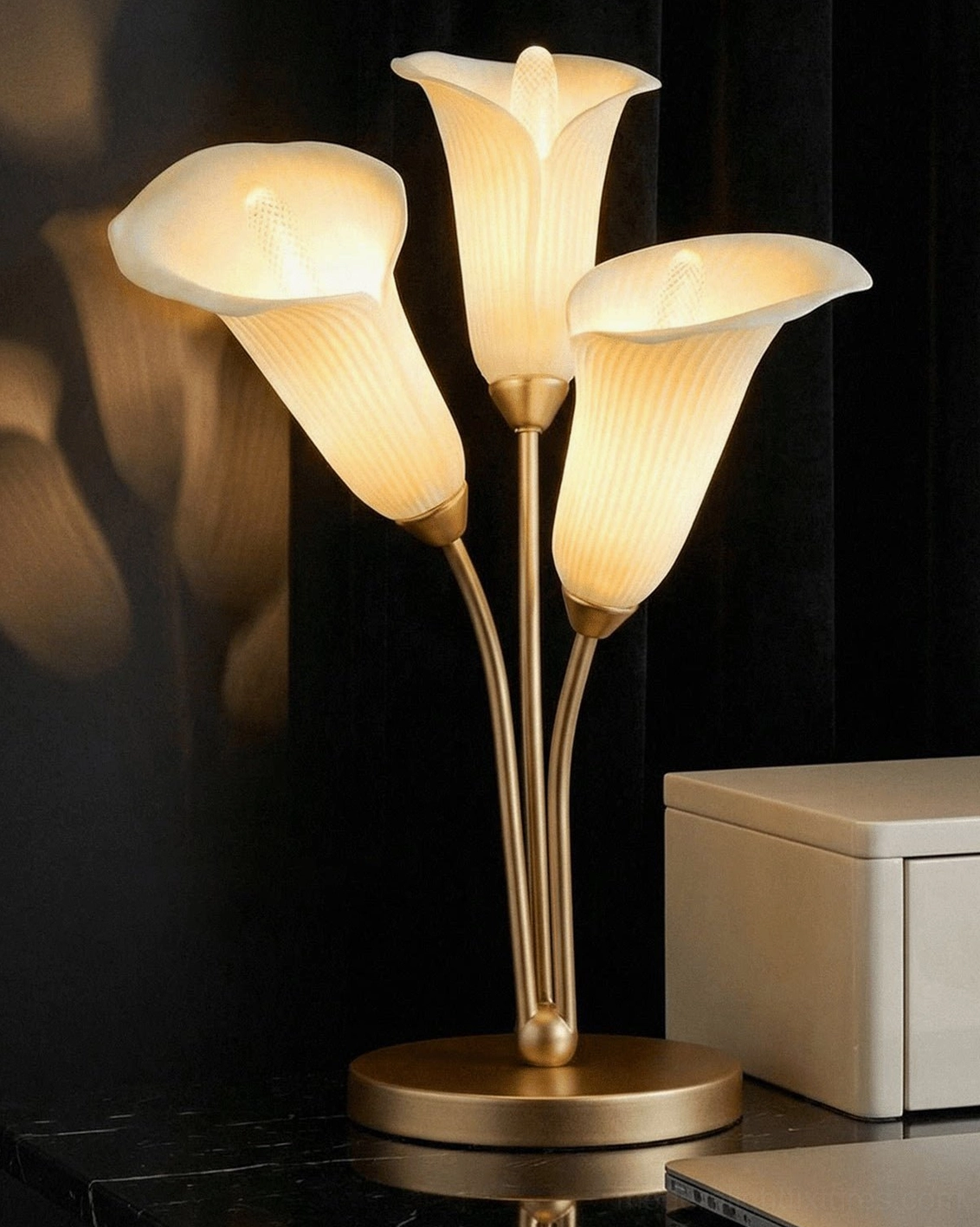 Contemporary calla lily table lamp on bedroom dresser with polished gold frame and off-white ribbed shades