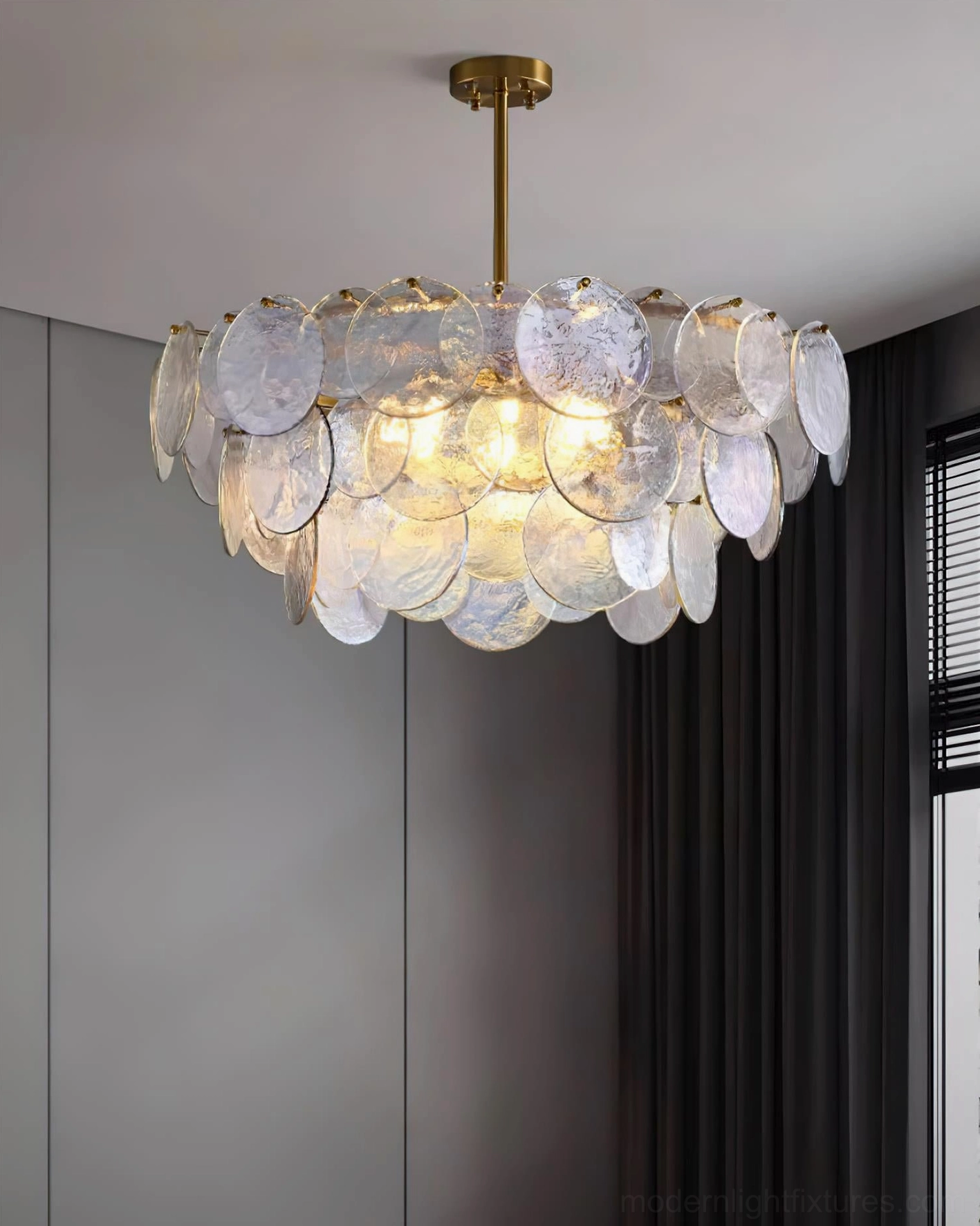Brass and glass disc chandelier three-quarter view in luxury interior with dark window treatments