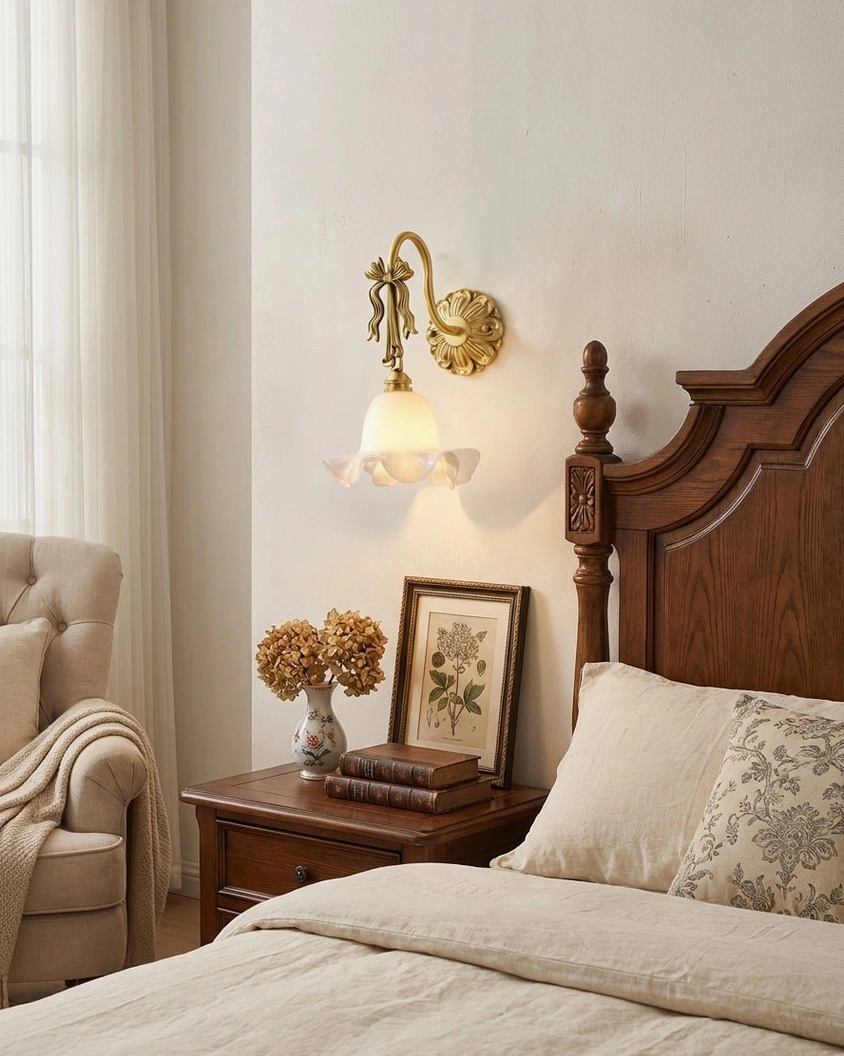Lysette wall sconce installed in traditional master bedroom providing warm ambient light above wooden nightstand with neutral French country décor
