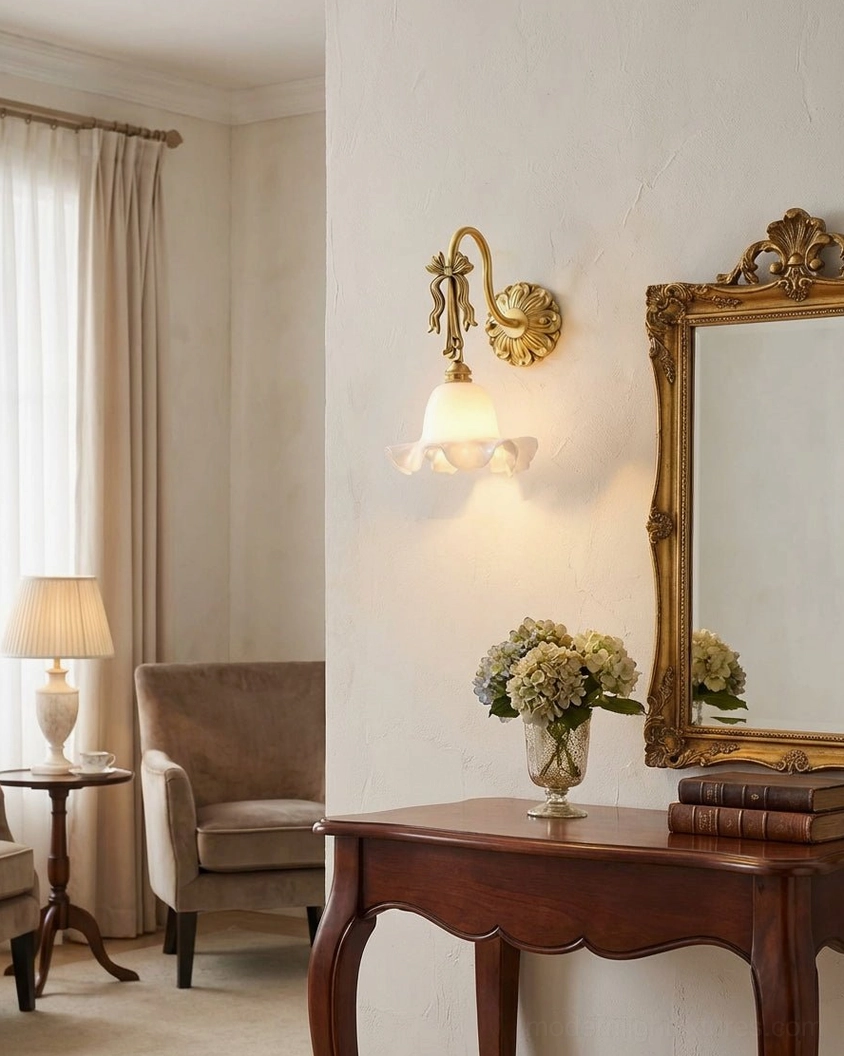 Lysette wall sconce illuminating vintage vanity area with gilded mirror and wooden side table, warm accent lighting