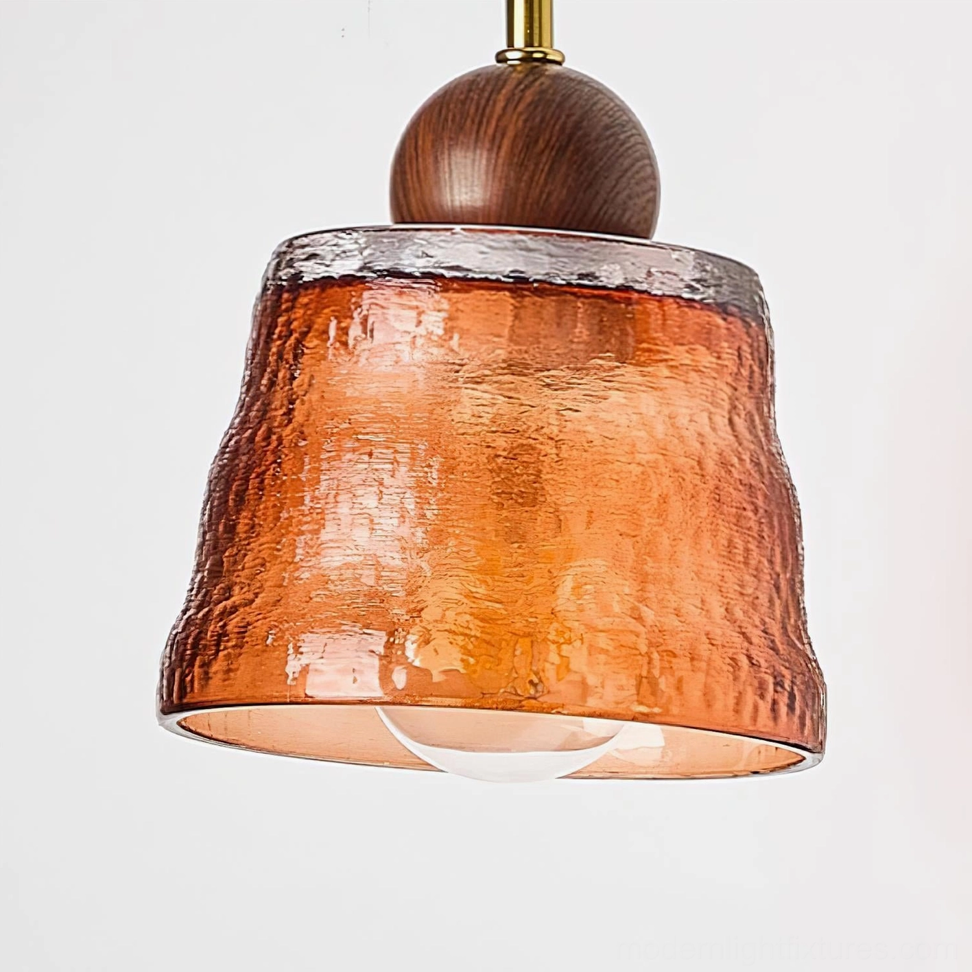 Lysora wall sconce detail view, curved brass arm, premium glass shade craftsmanship
