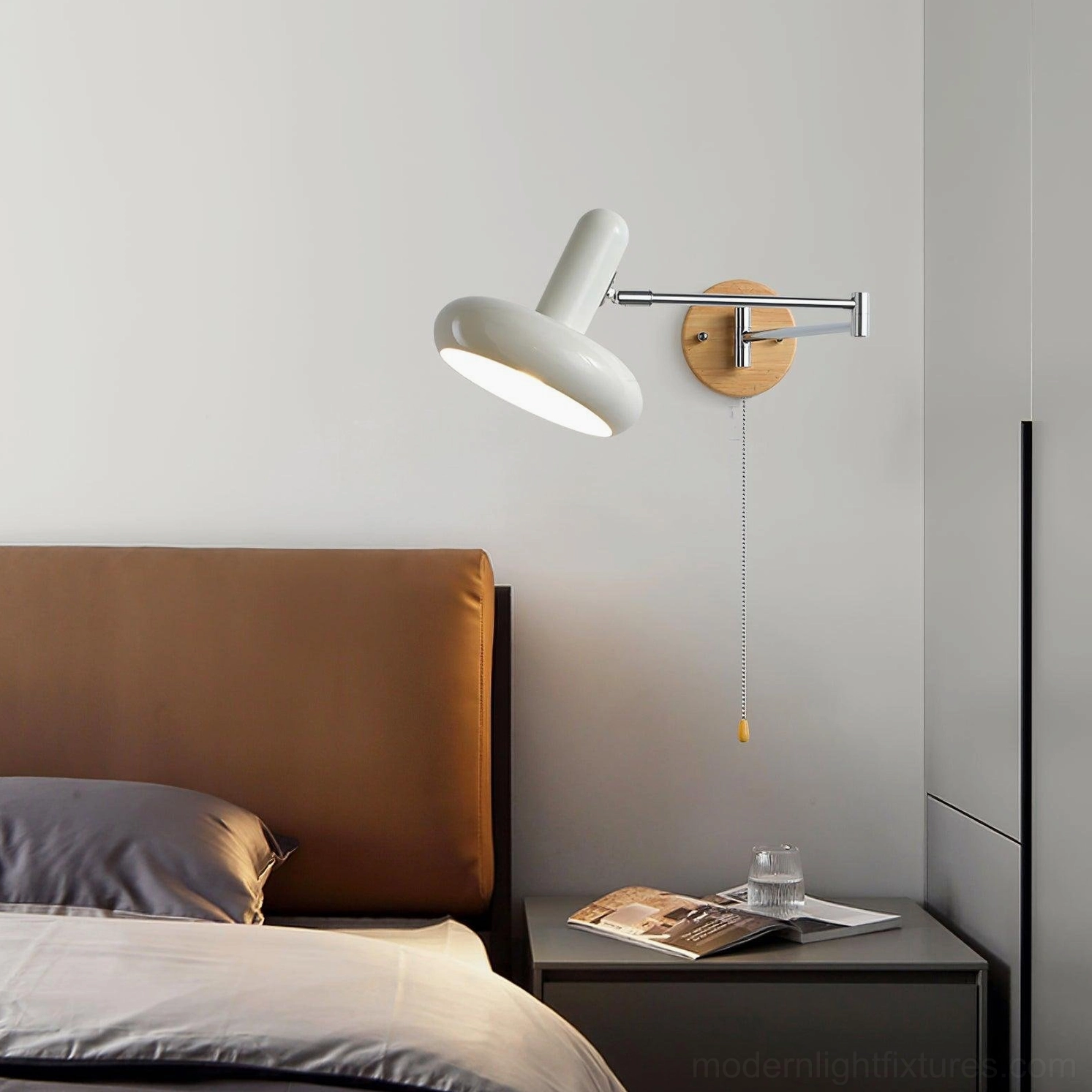 Maddie mid-century modern swing arm sconce installed in master bedroom beside nightstand with neutral home decor