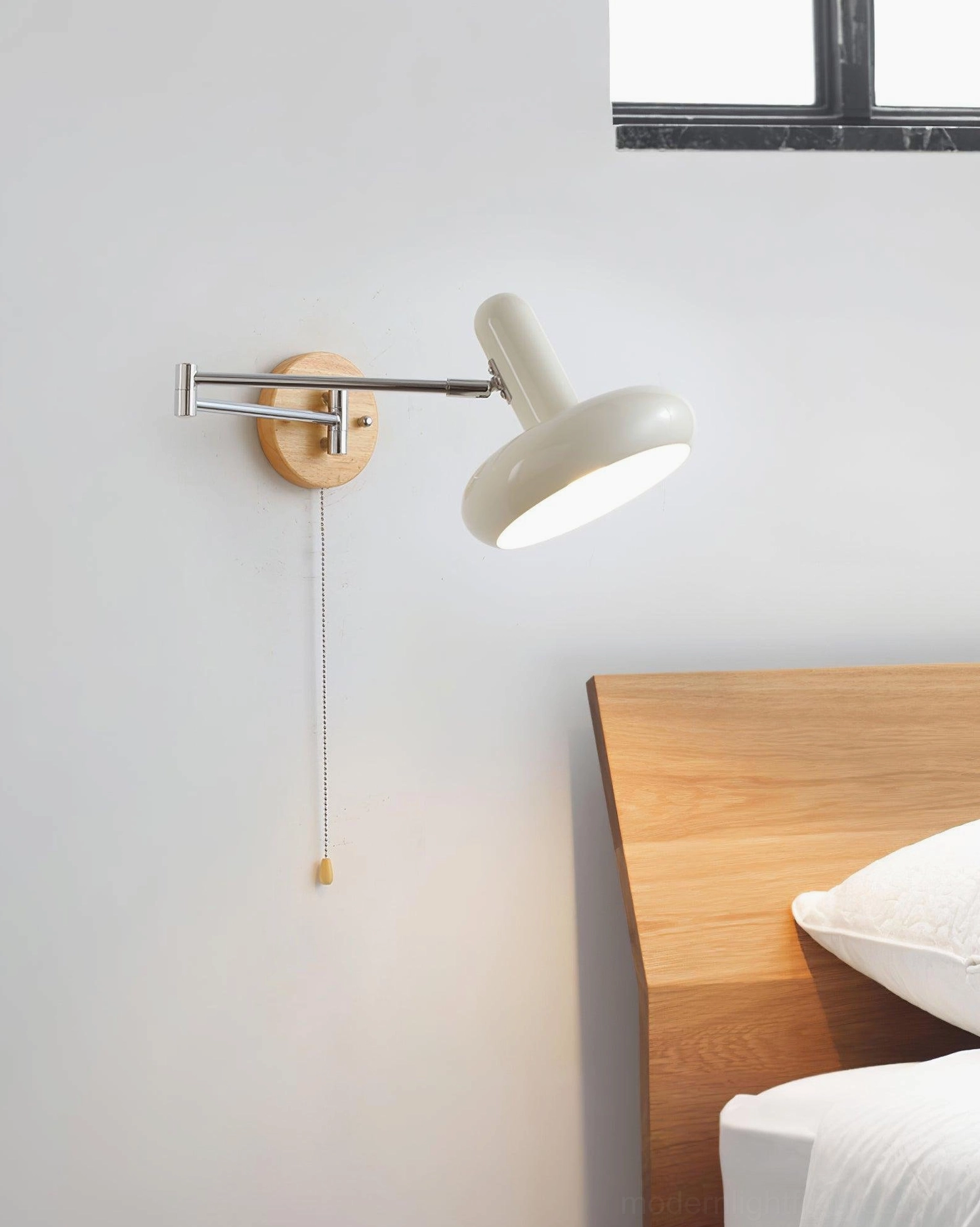 Maddie adjustable wall sconce in bedroom with wooden headboard bed, pull cord with wooden toggle pendant visible