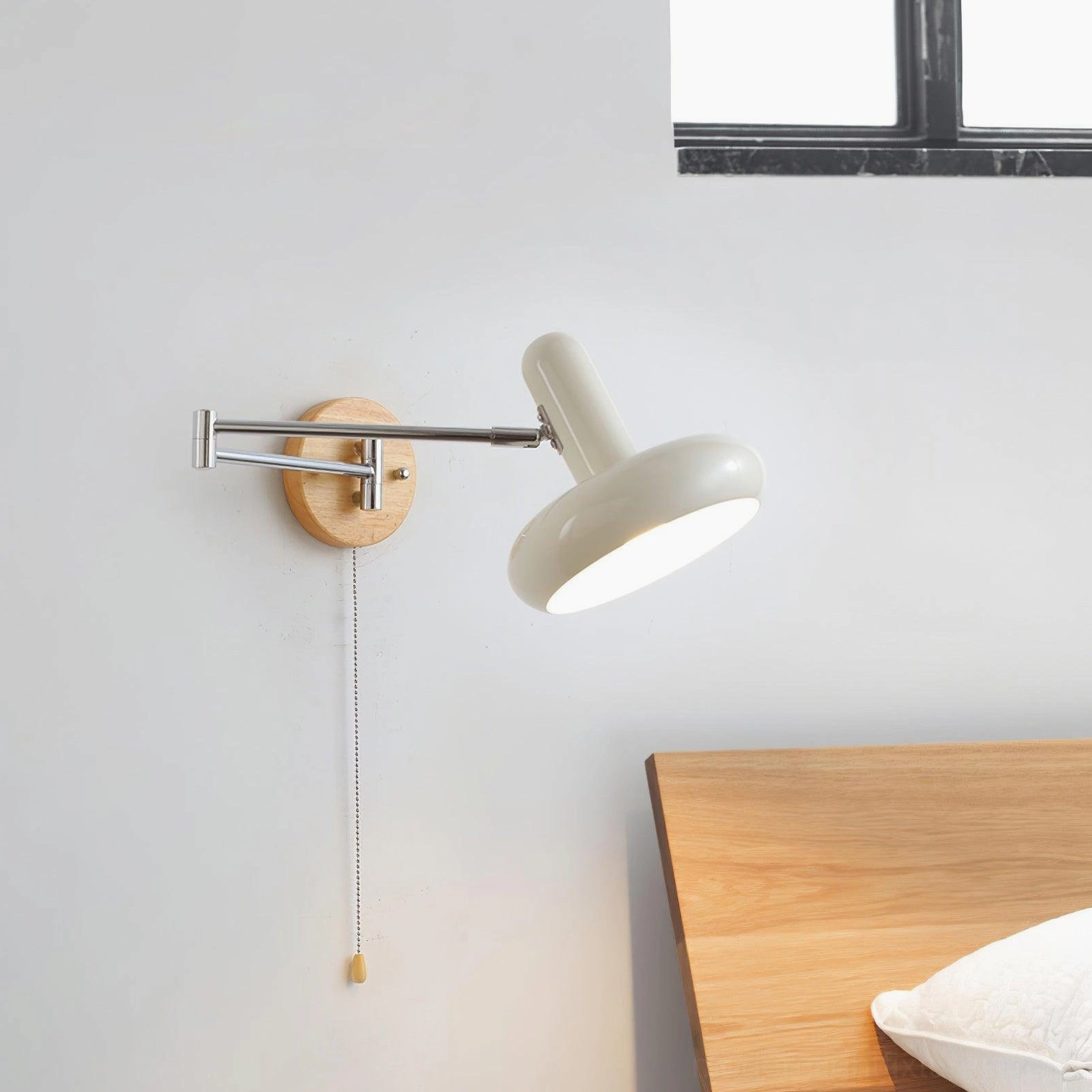 Maddie swing arm wall sconce low angle front view in bedroom with wooden headboard and simple backdrop