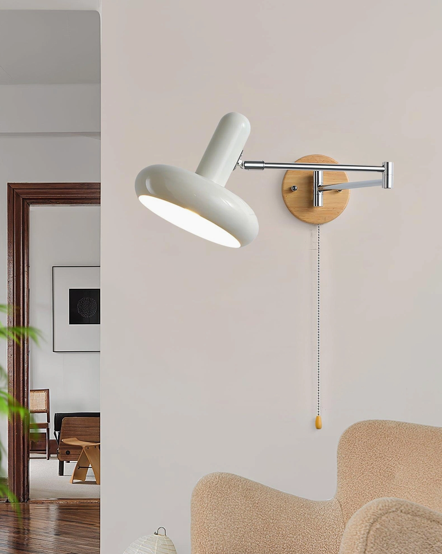 Maddie adjustable wall sconce positioned beside boucle upholstered armchair in contemporary living room setting