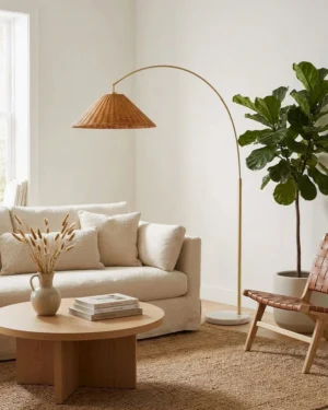 Madera arc floor lamp positioned in modern bohemian living room beside fabric sofa and round coffee table - interior styling