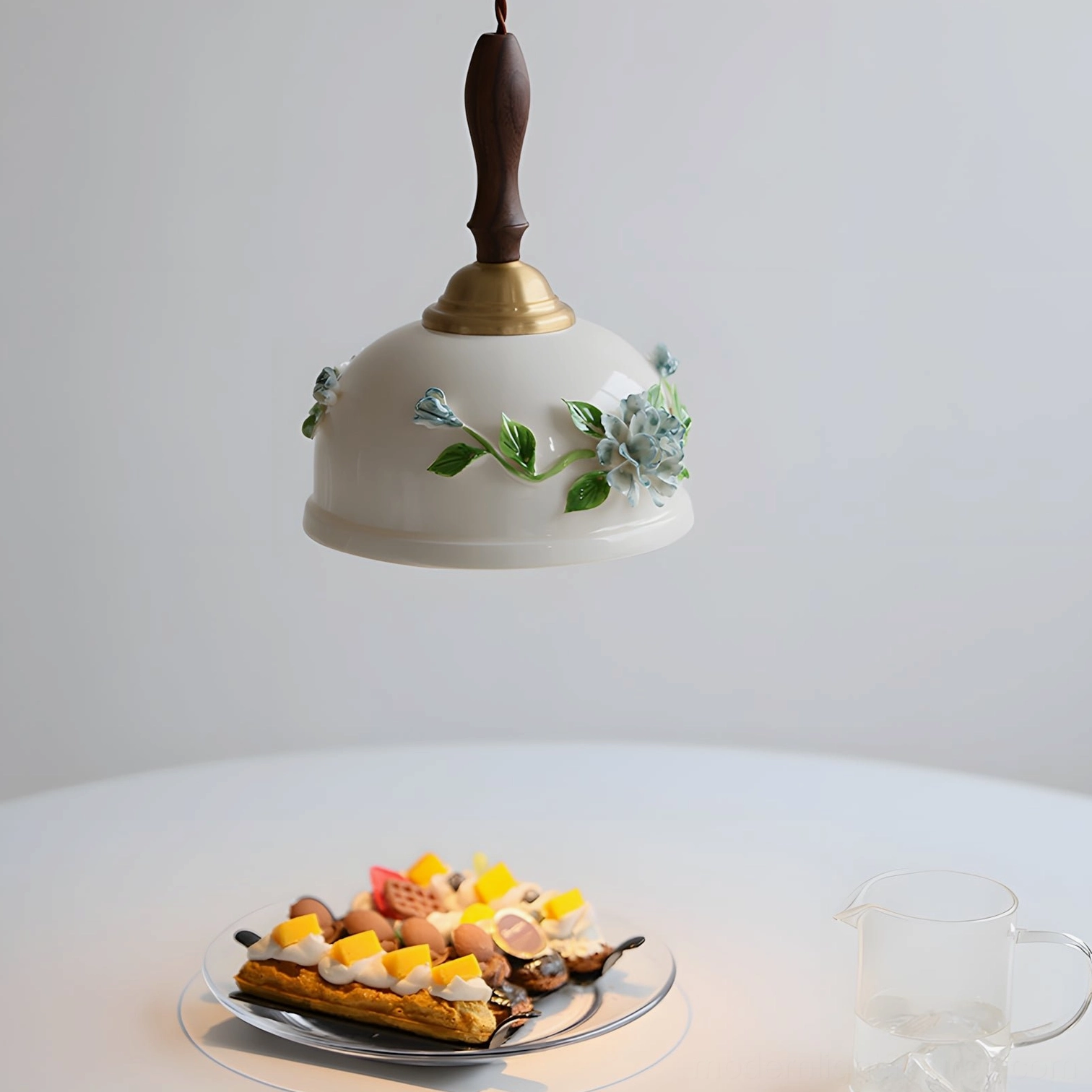Maelis ceramic pendant lamp close-up top view above dining table, showcasing blue flower and green leaf hand-painted botanical design