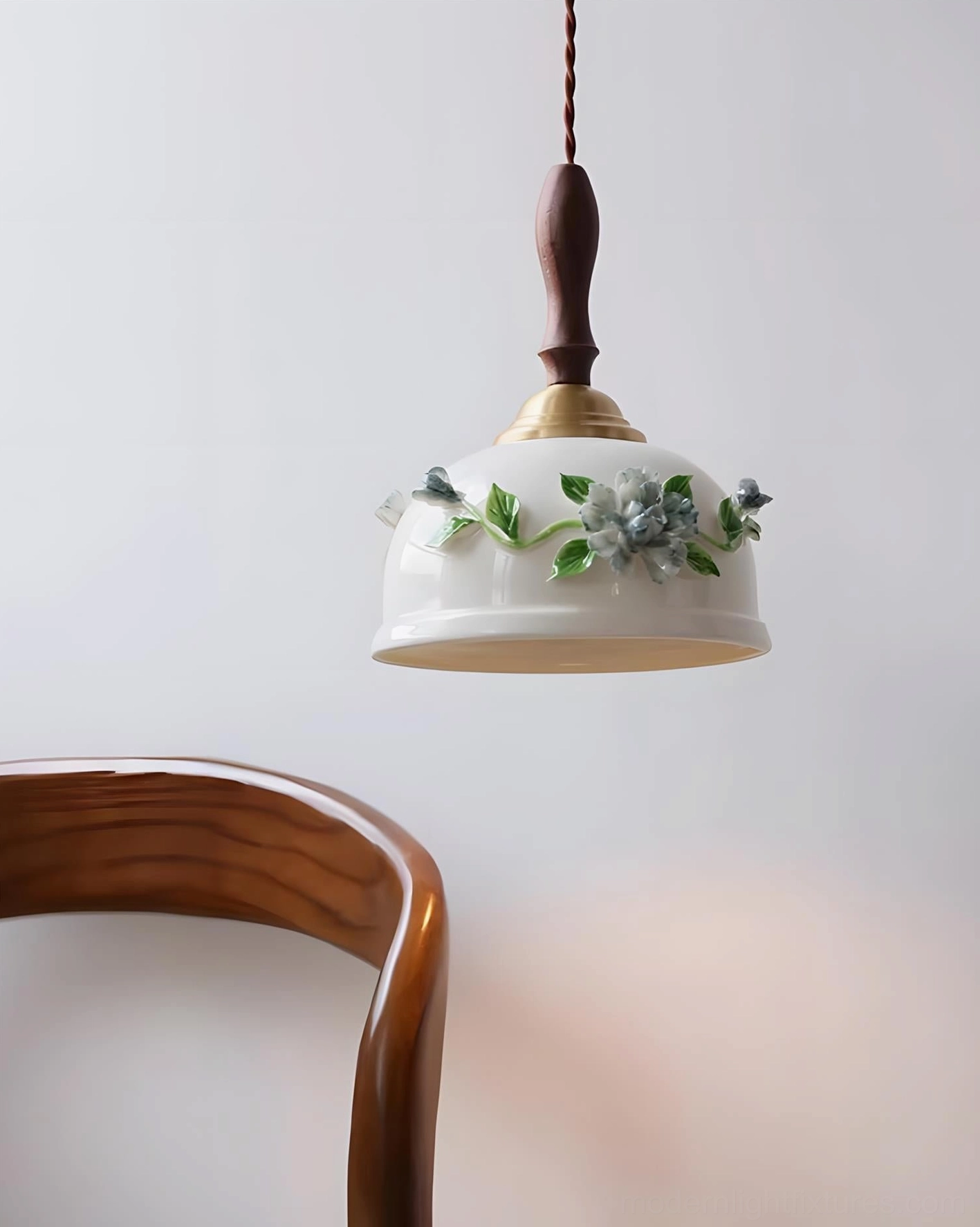 Maelis handcrafted ceramic pendant lamp with compact sculptural design and floral ceramic shade near wooden dining chair, oblique angle