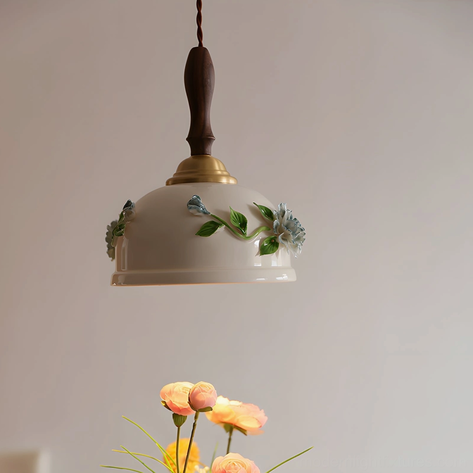 Maelis ceramic pendant light with brass hardware and wooden stem, oblique angle showing botanical hand-painted details and warm brass accents
