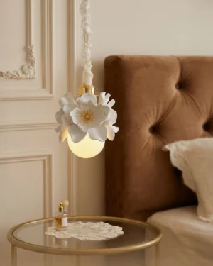 Magnelle pendant light glowing warmly in French bedroom beside brown tufted headboard, creating intimate ambient lighting for bedroom interior design