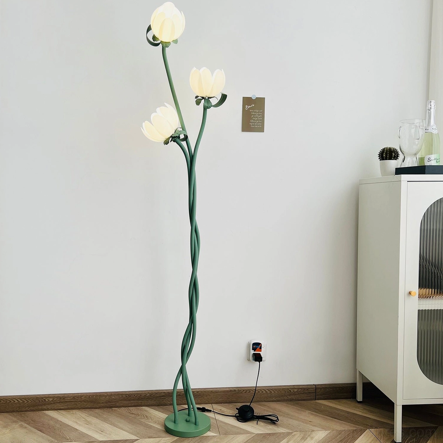 Magnolia floor lamp sculptural design with organic green stem and botanical white bloom shades in Nordic decor setting