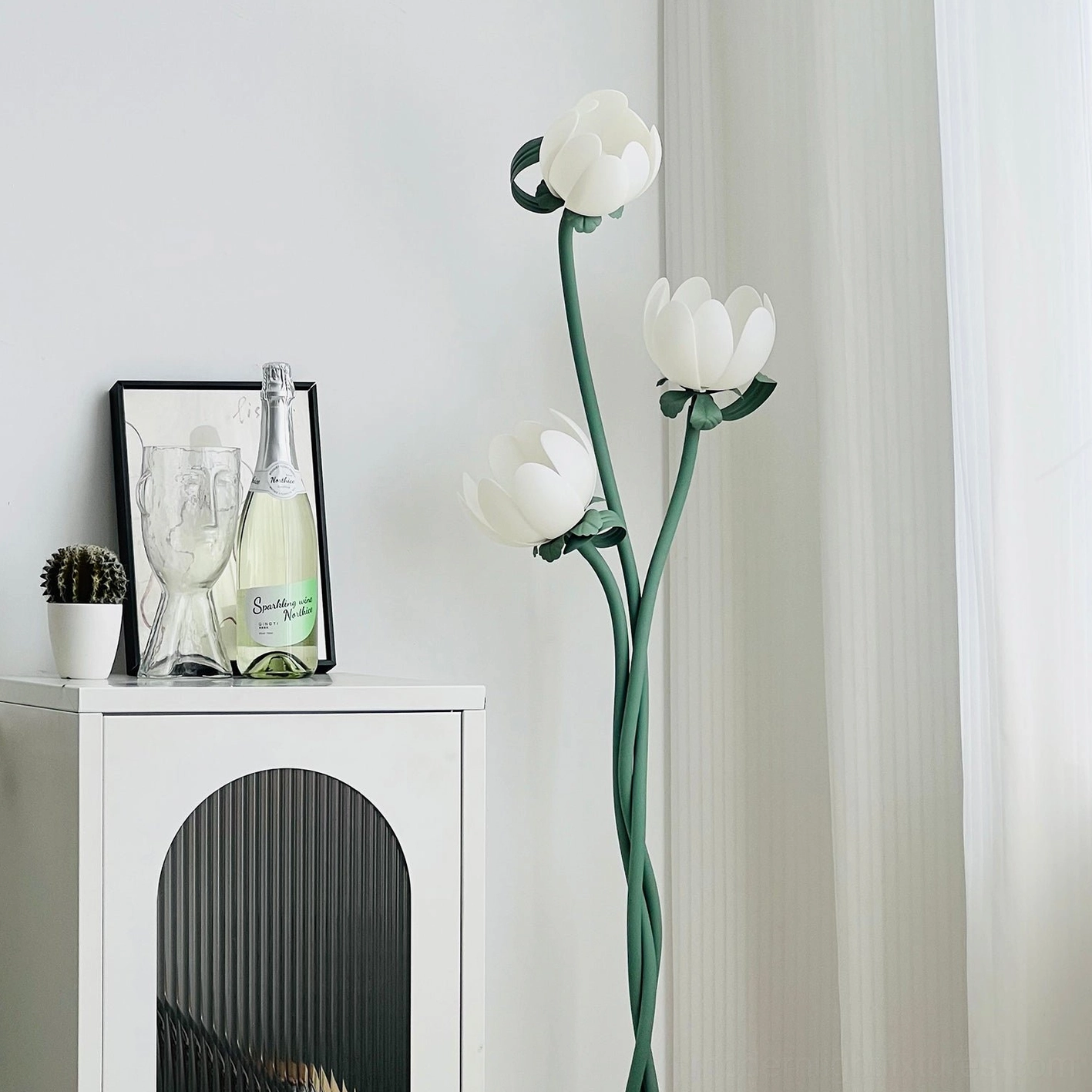 Three-head magnolia floor lamp with integrated LED technology creating ambient lighting in modern minimalist space