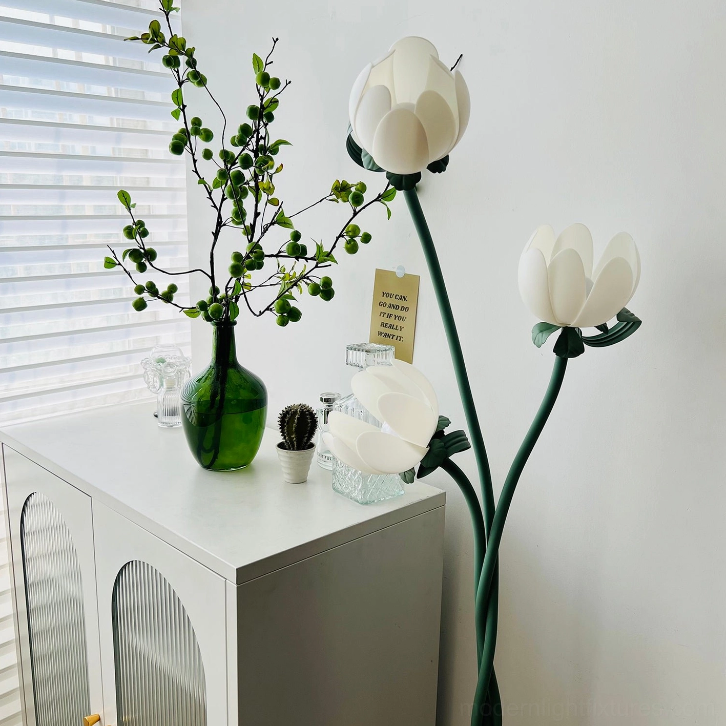 Magnolia bud floor lamp detail showing white acrylic bloom lampshade and twisted green metal stem structural design