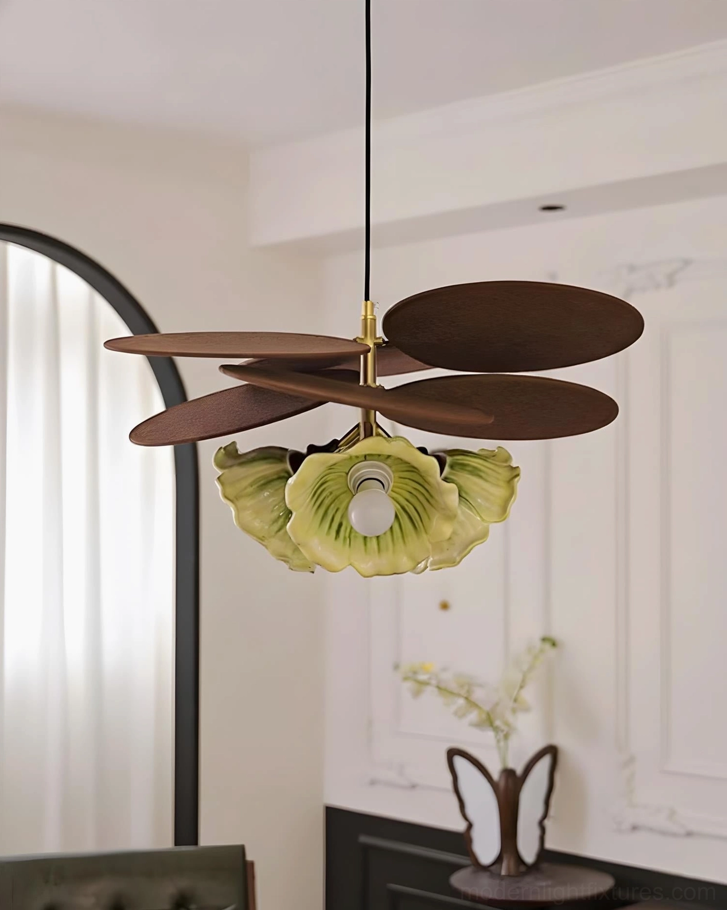 Magnolia sculptural pendant light with large green leaf-shaped shade and dark brown wooden accents, studio view